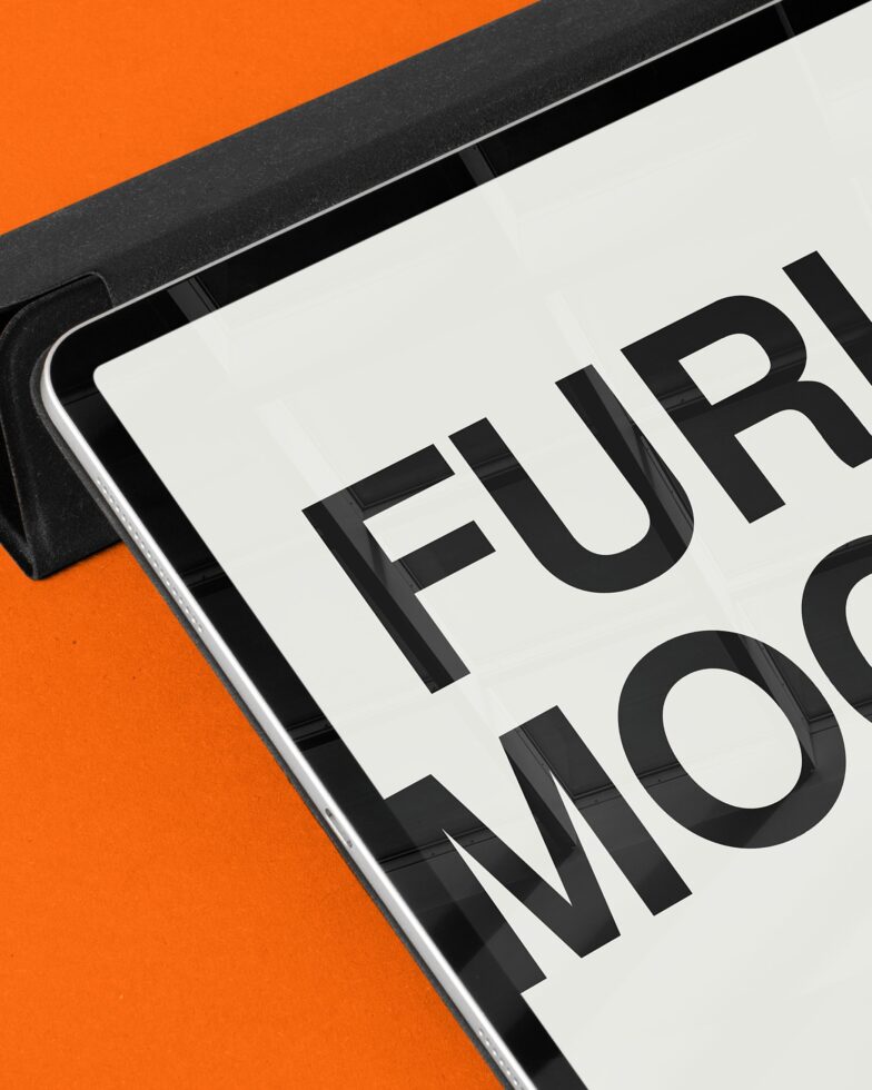 Close-up of tablet edge with Furioso text on orange background split composition