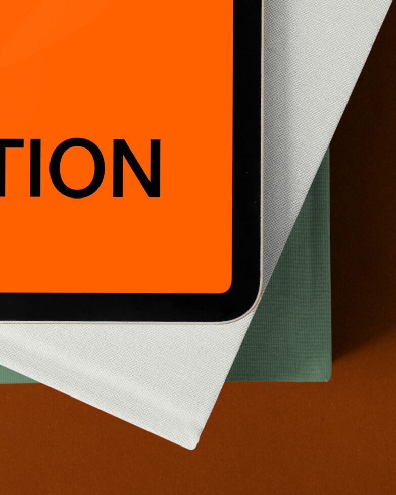 Orange card with partial text on brown background with layered paper samples