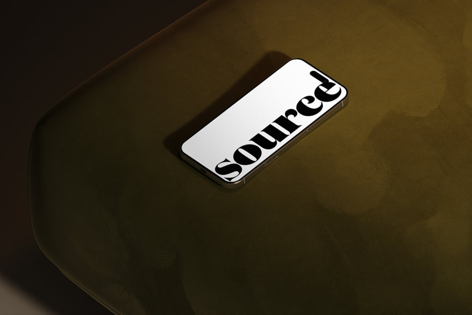 Phone displaying diagonal black lettering on khaki colored surface