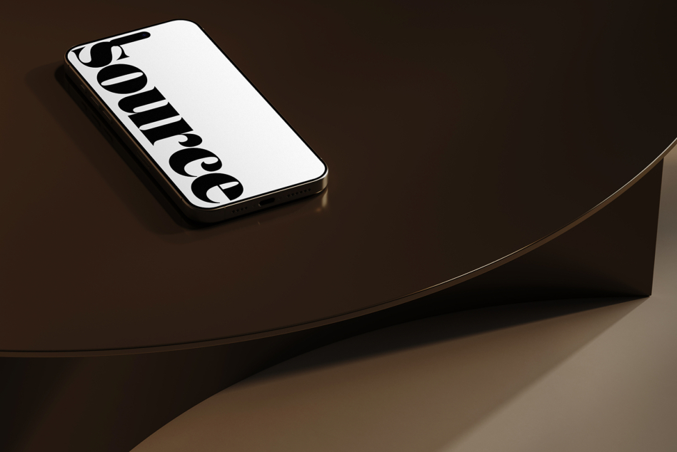 iPhone displaying vertical black typography on curved wooden surface