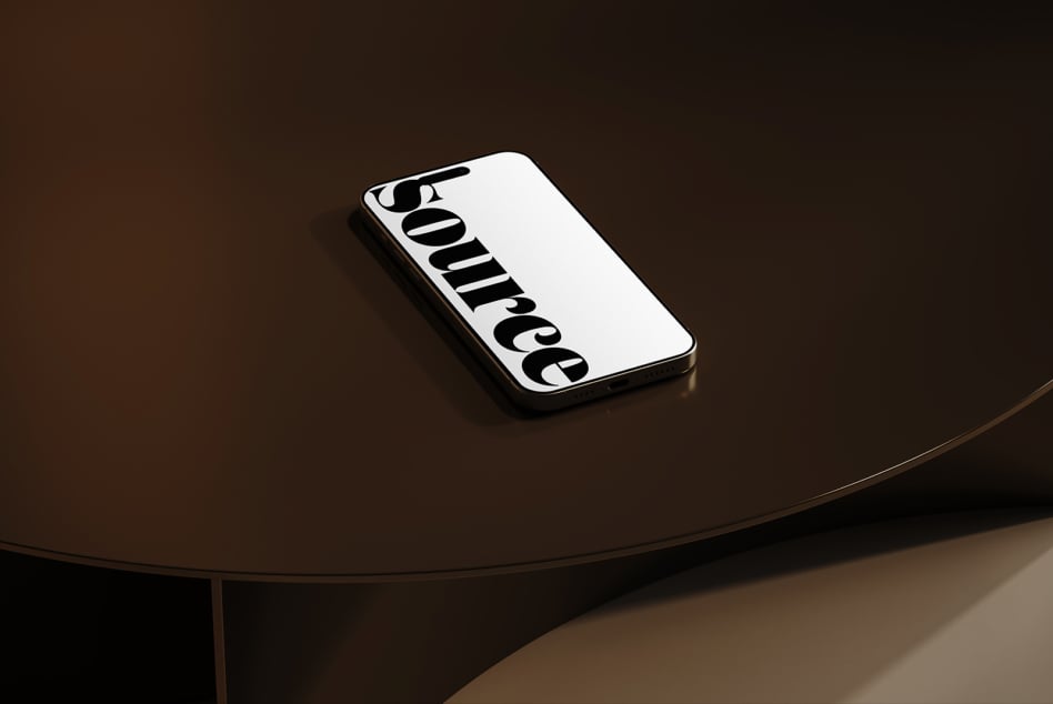 Phone mockup with black serif lettering centered on minimalist table