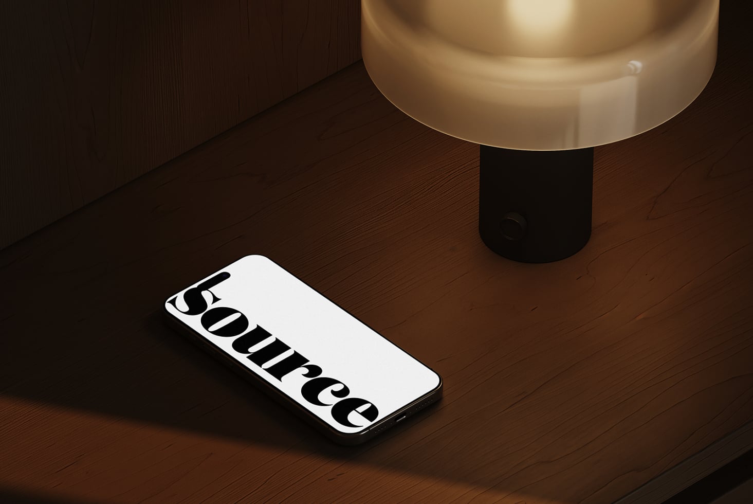 Phone on wood table under warm light displaying serif type design