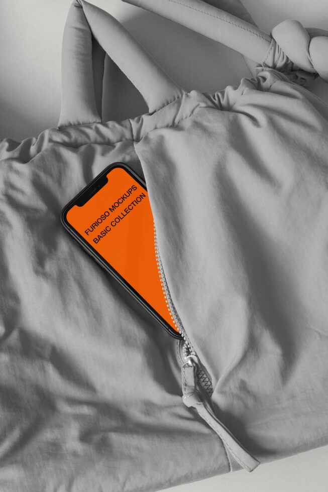 Smartphone with orange screen peeking from white jacket pocket, black white aesthetic