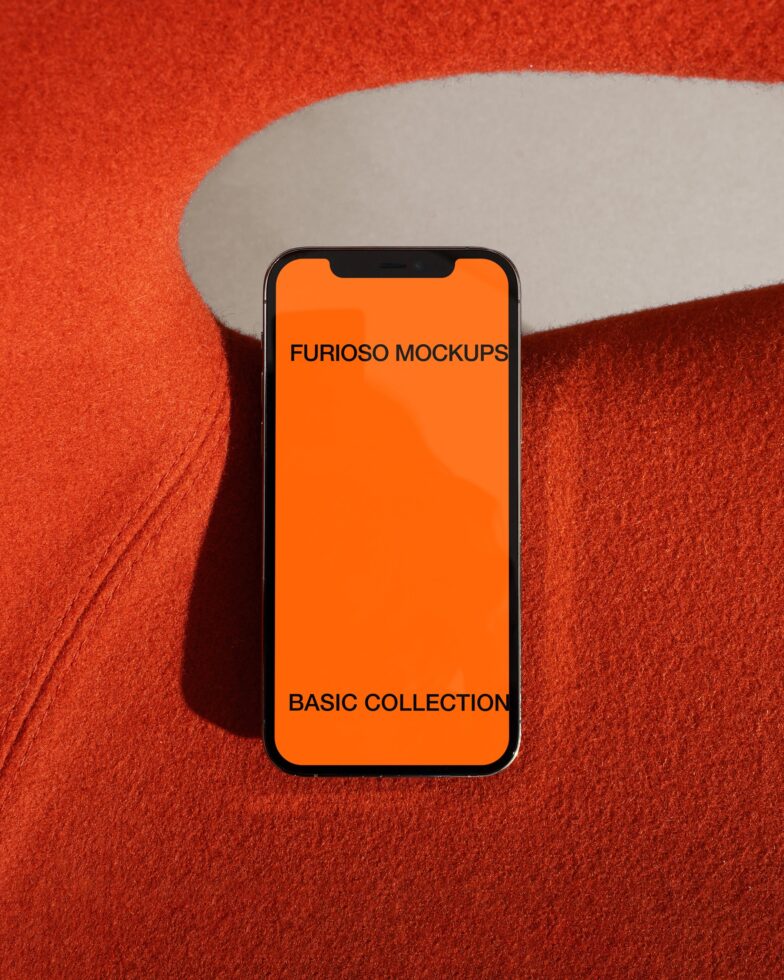 Phone mockup on textured red surface with orange display screen