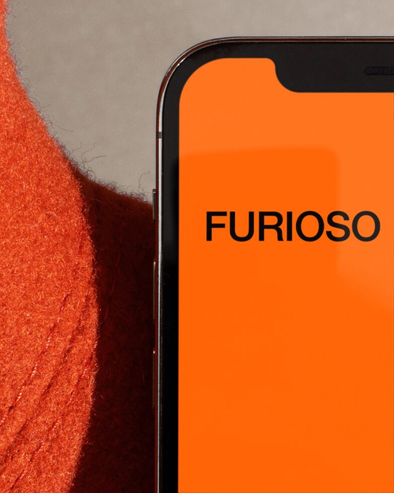 Smartphone screen mockup with orange background next to red fabric