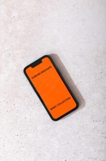 Overhead shot of iPhone with black case showing bright orange display mockup