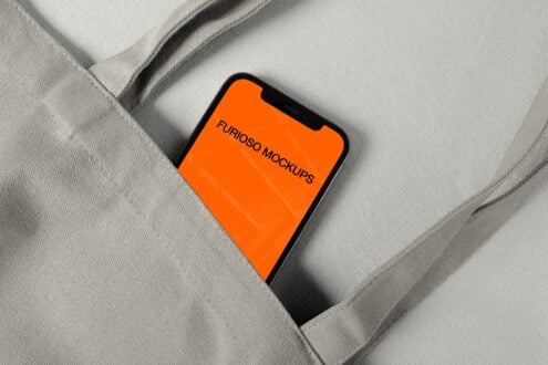 iPhone with bright orange screen sitting on folded gray fabric