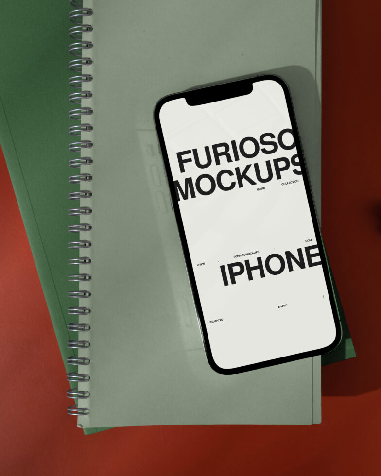 Mobile phone displaying minimalist text layout on green spiral bound notebook