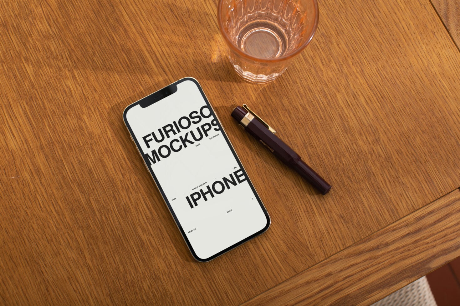 White iPhone mockup on wooden table with pen, glass, cosmetic products