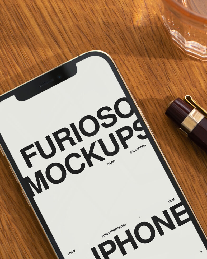 iPhone mockup with white screen on wooden desk next to perfume bottle
