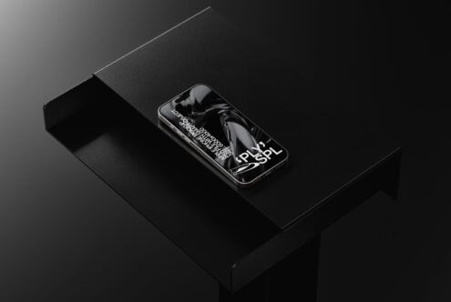 Phone showing abstract black liquid imagery on dark surface setup
