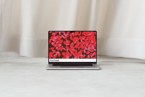 Silver laptop displaying colorful red pink leaf pattern with normaal text