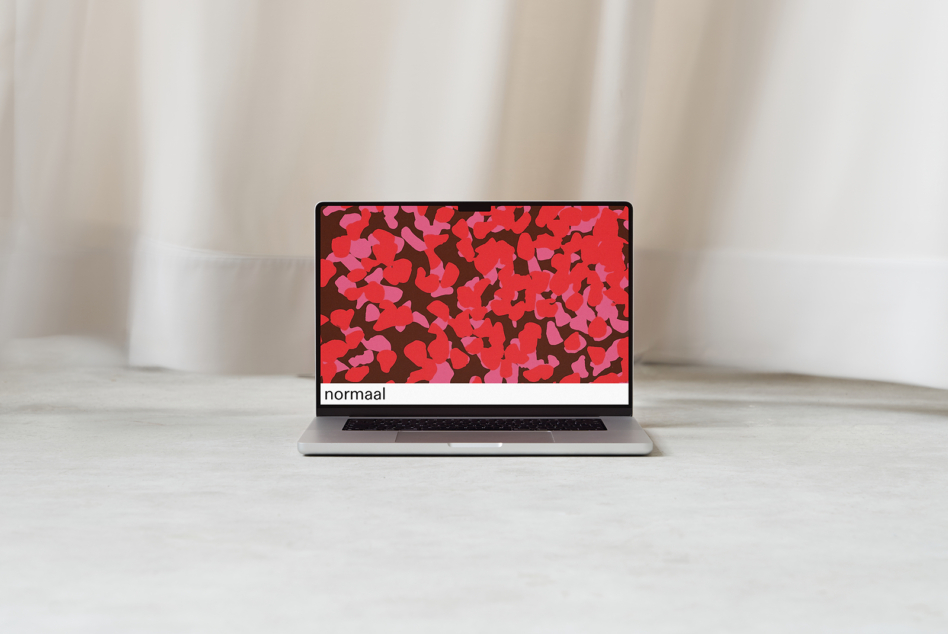 Silver laptop displaying colorful red pink leaf pattern with normaal text