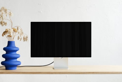 Desktop monitor mockup with blue vase, dried flowers, clean workspace
