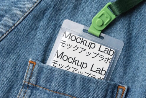 Clear ID badge with green strap attached to light blue denim jacket