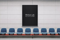 Black poster mockup mounted on white wall with blue chairs seated below