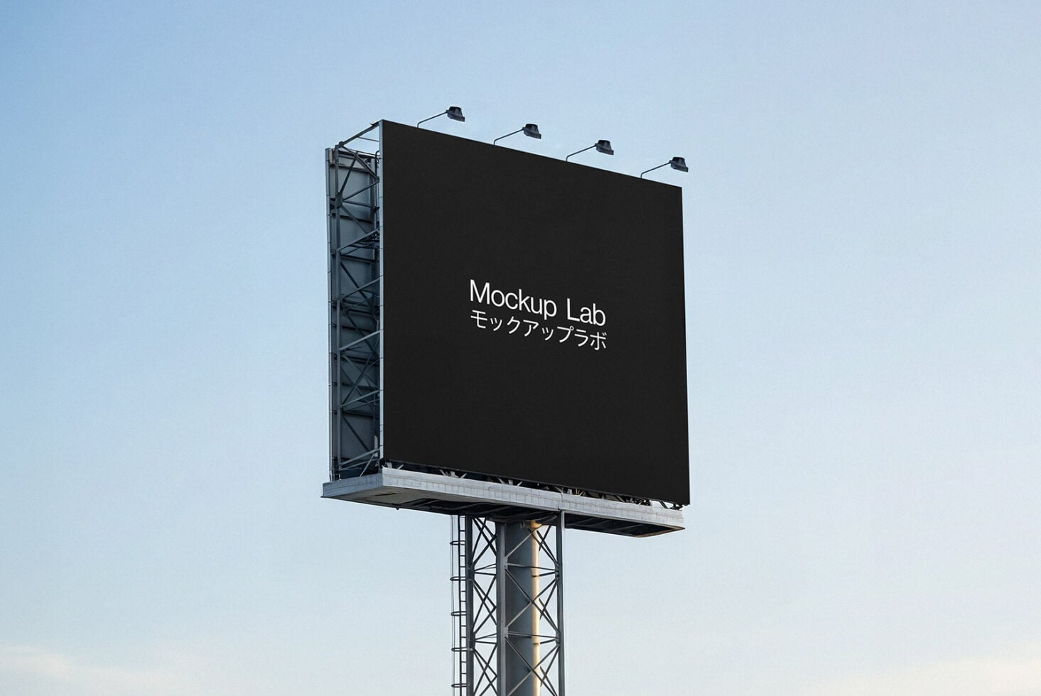 Dark billboard on steel pole with four stadium-style lamps overhead