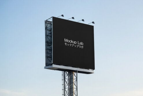 Dark billboard on steel pole with four stadium-style lamps overhead