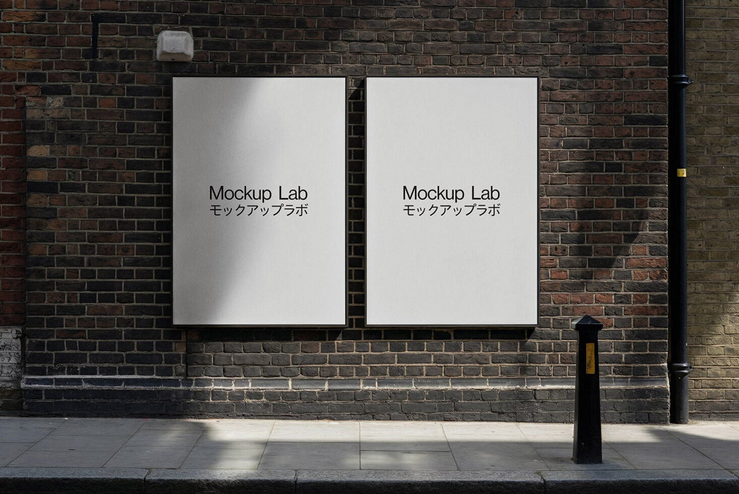 Two white poster frames mounted on brick wall with sunlight casting shadows