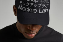 Front view of person wearing black baseball cap with white text stripe design