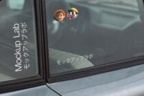 Car window sticker mockup with two cute character figures on gray tinted glass