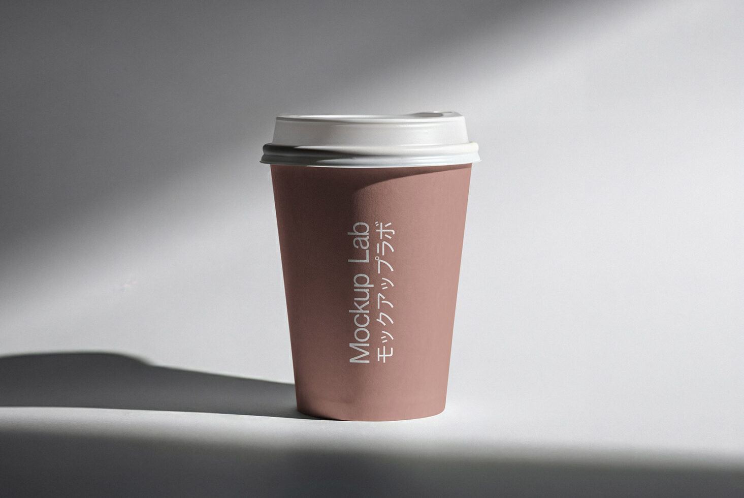 Rose-toned paper cup with white lid showing vertical text placement mockup