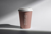 Rose-toned paper cup with white lid showing vertical text placement mockup