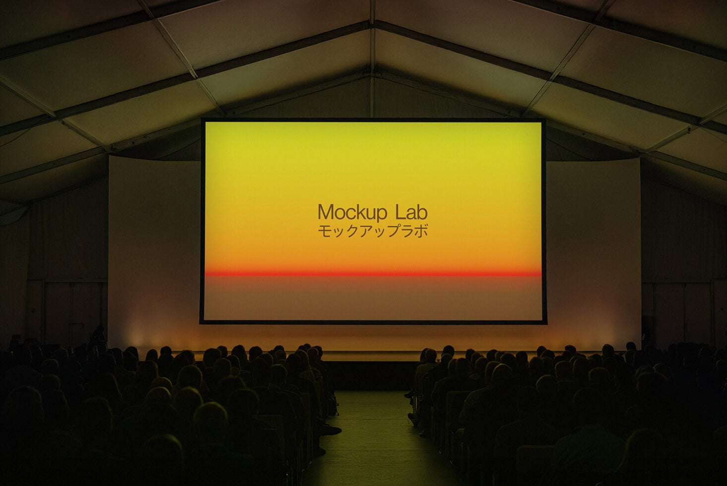 Large projection screen in auditorium showing sunset gradient with Mockup Lab text