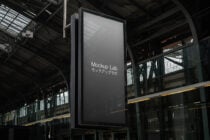 Empty metal sign display hanging from structure with dark industrial setting