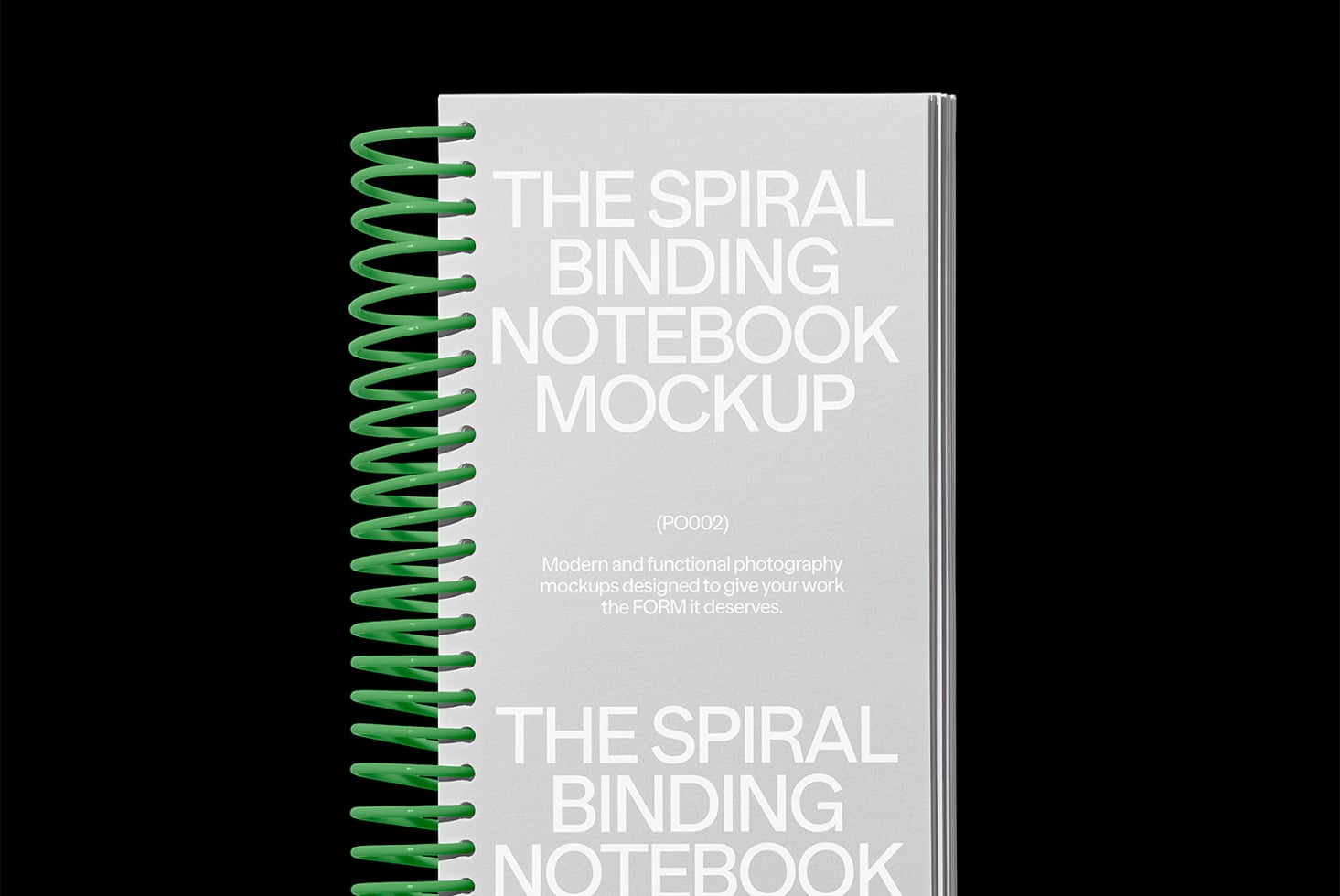 Spiral bound notebook with green coil binding shown against dark background