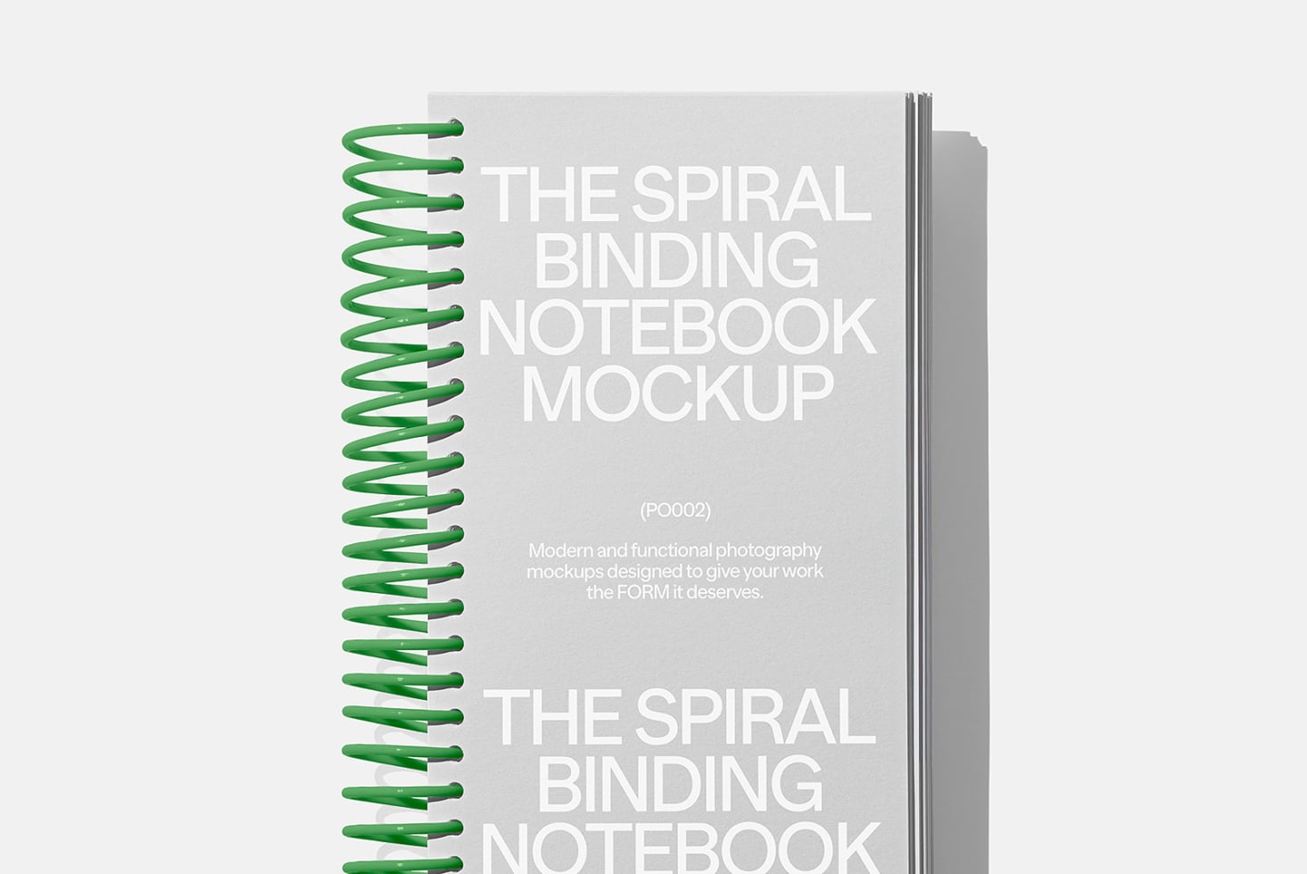 Spiral notebook with green coil binding on light gray background mockup
