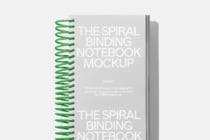 Spiral notebook with green coil binding on light gray background mockup