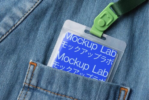 Blue ID card holder with green lanyard on blue denim fabric background