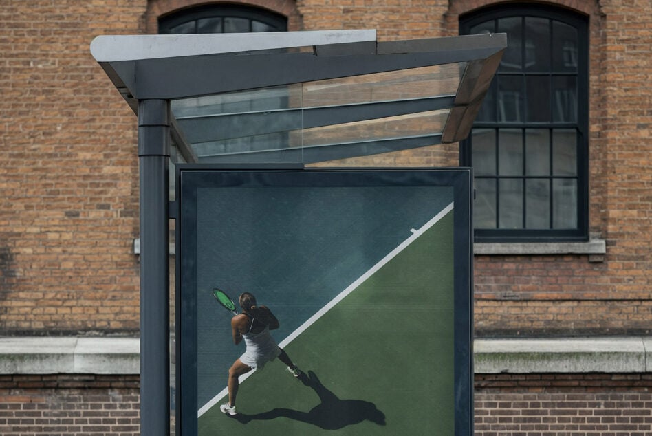 Modern bus shelter ad with tennis player serving on green court design