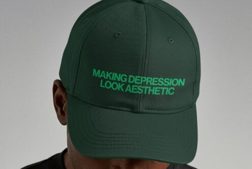 Back view of person wearing dark green baseball cap with bright green embroidered text