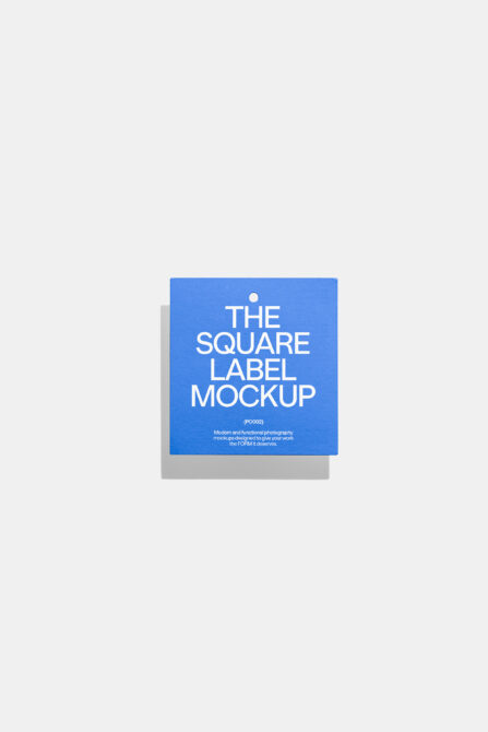 Square blue product label with hole punch on neutral background with shadow