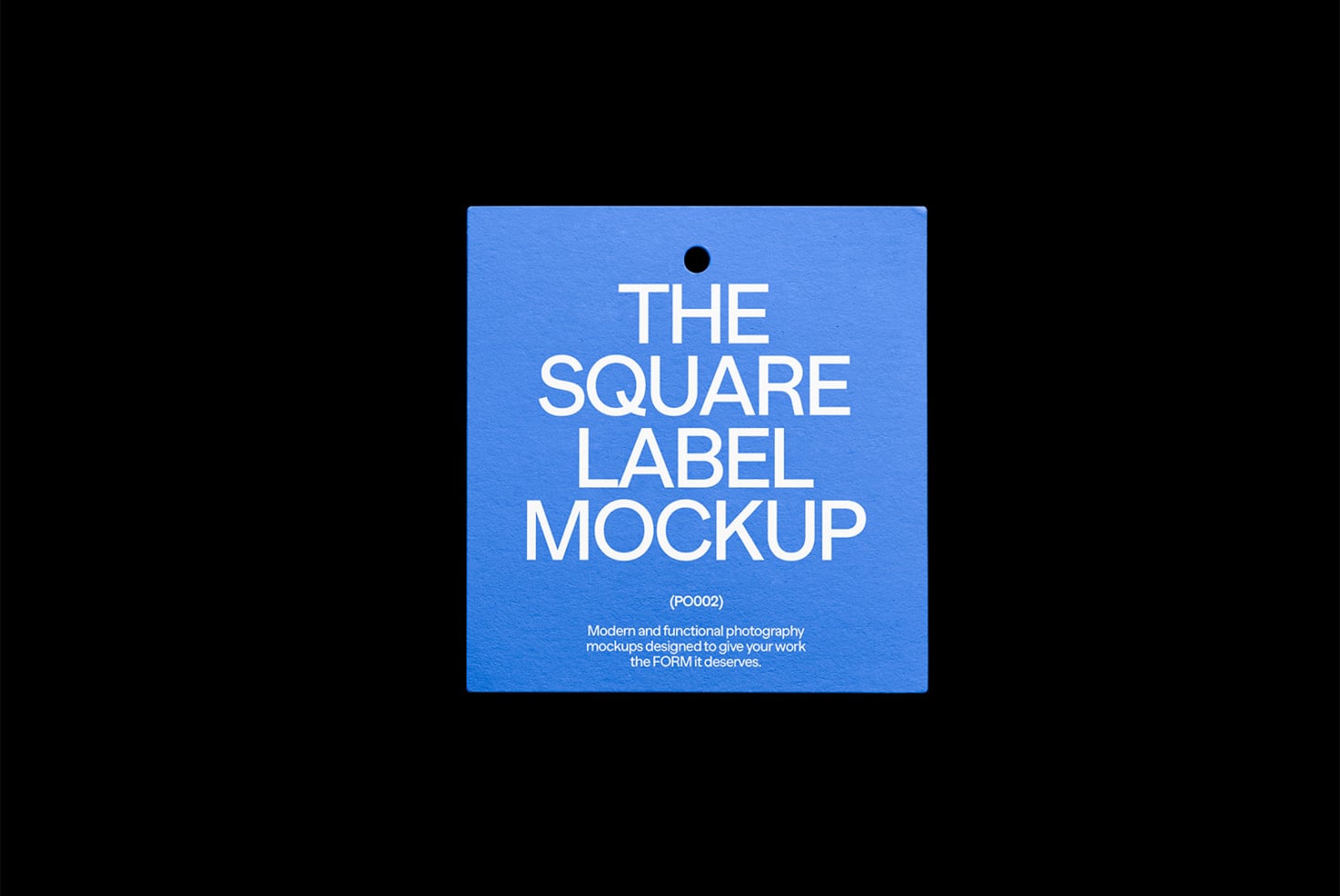 Square blue hanging product tag with hole punch against dark background