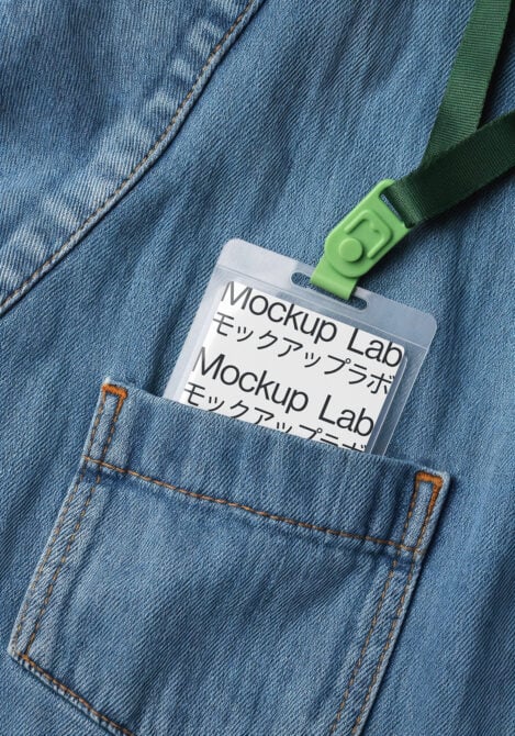ID badge with green lanyard clipped to light blue denim jacket pocket
