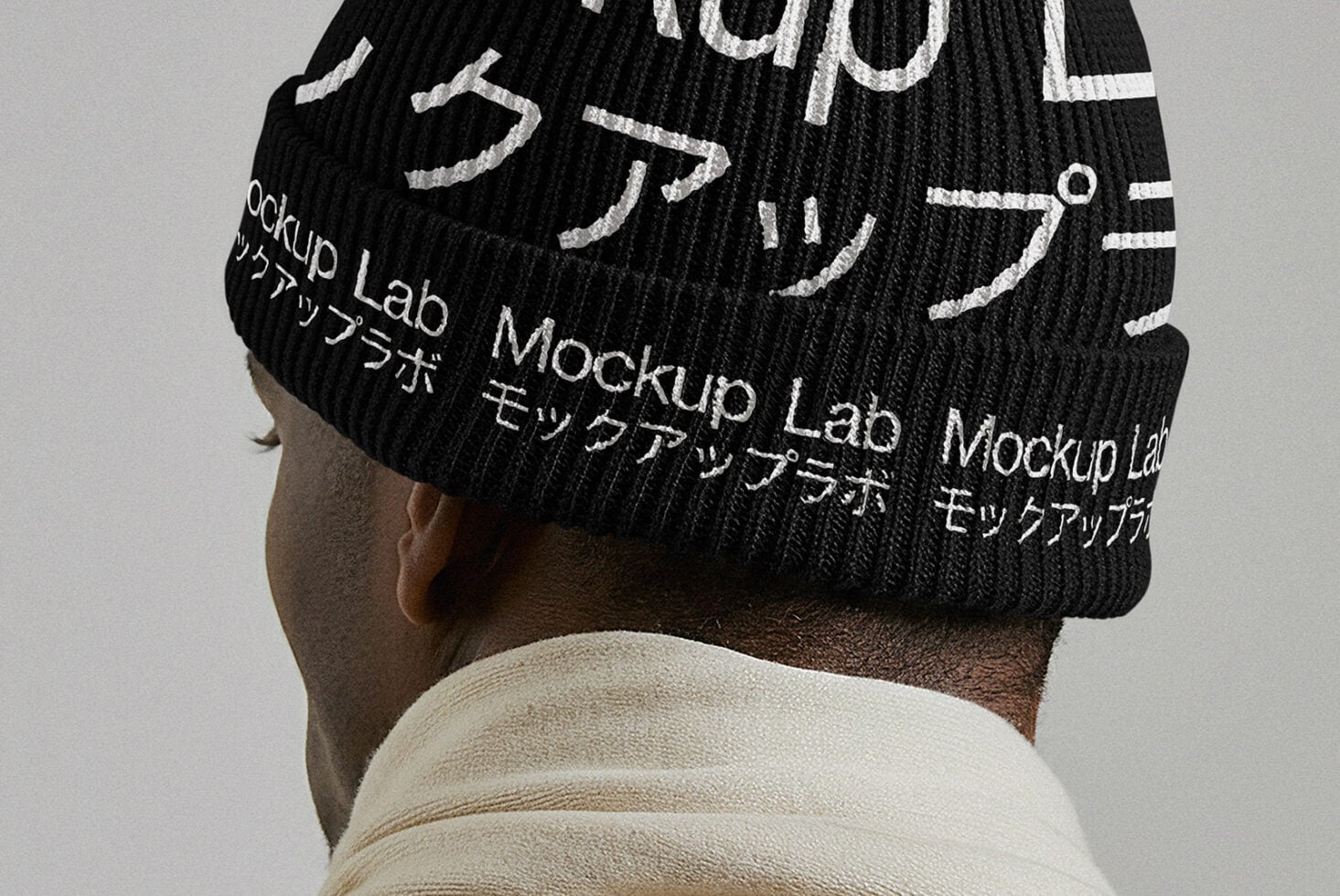 Back view of person wearing black knit beanie with white text overlay