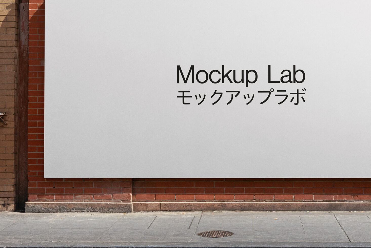 White billboard on brick wall showing Mockup Lab text in English plus Japanese
