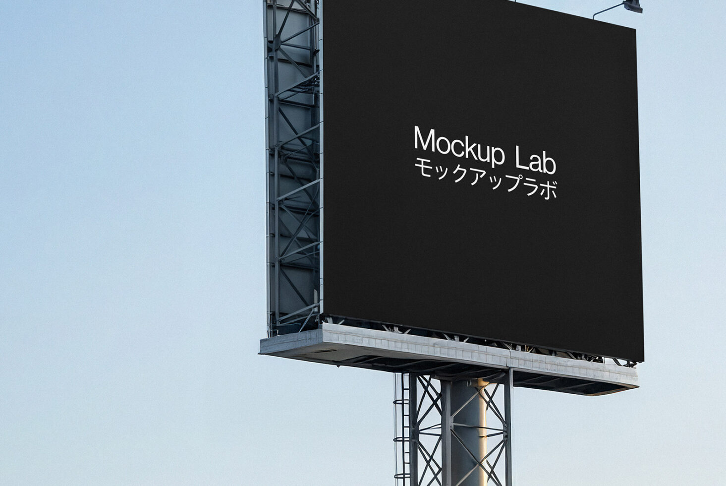 Large black billboard on metal structure against clear sky