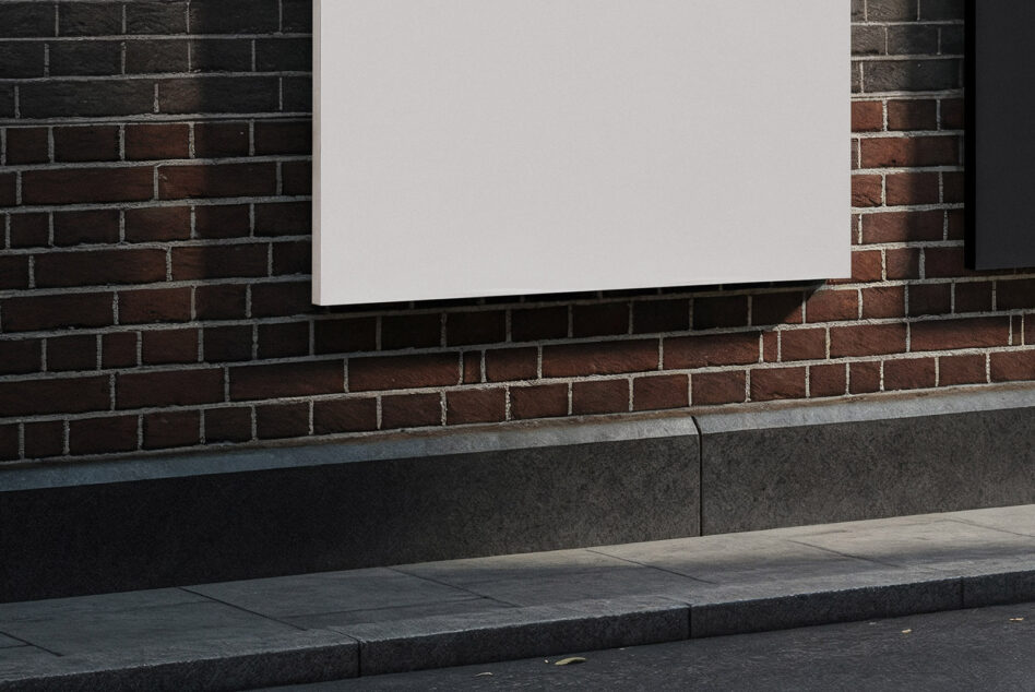 Blank horizontal white signage mounted on dark brick exterior wall