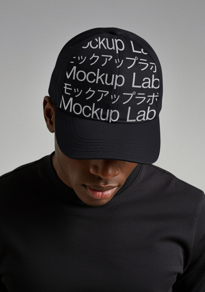 Front view of person wearing black baseball cap with repeated text overlay mockup