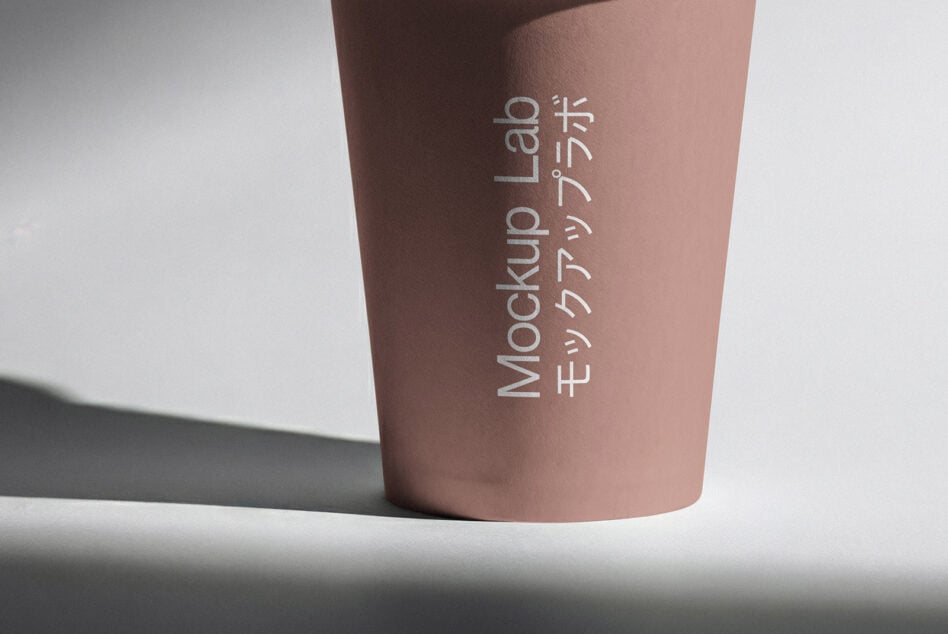 Mauve takeaway cup with vertical white text mockup on clean background