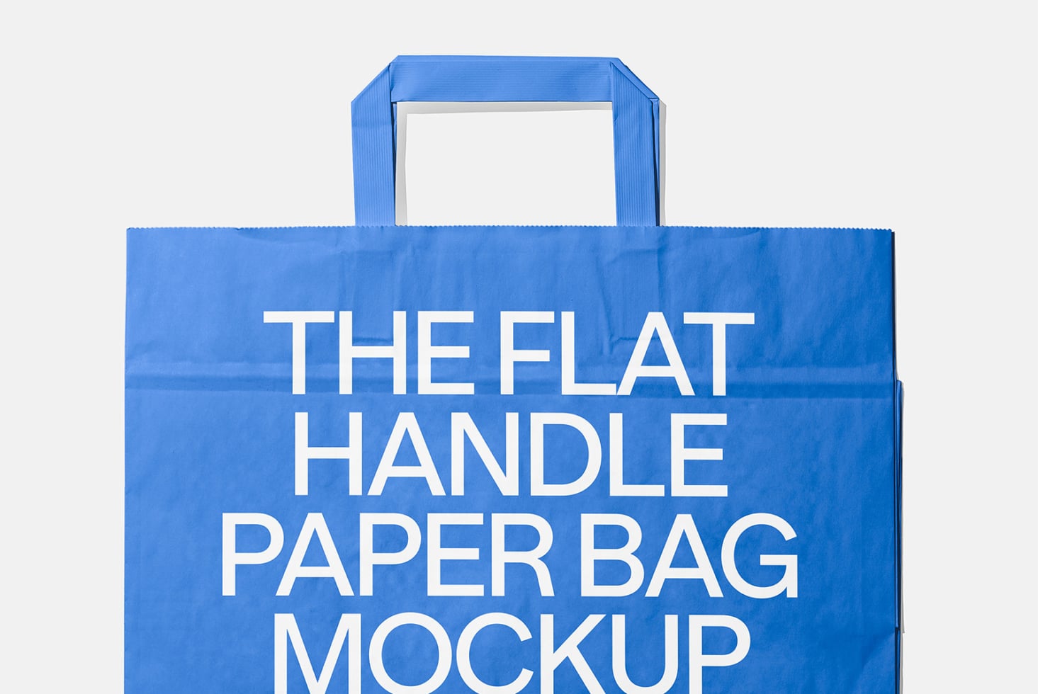 Blue paper shopping bag with flat handles on light gray background mockup