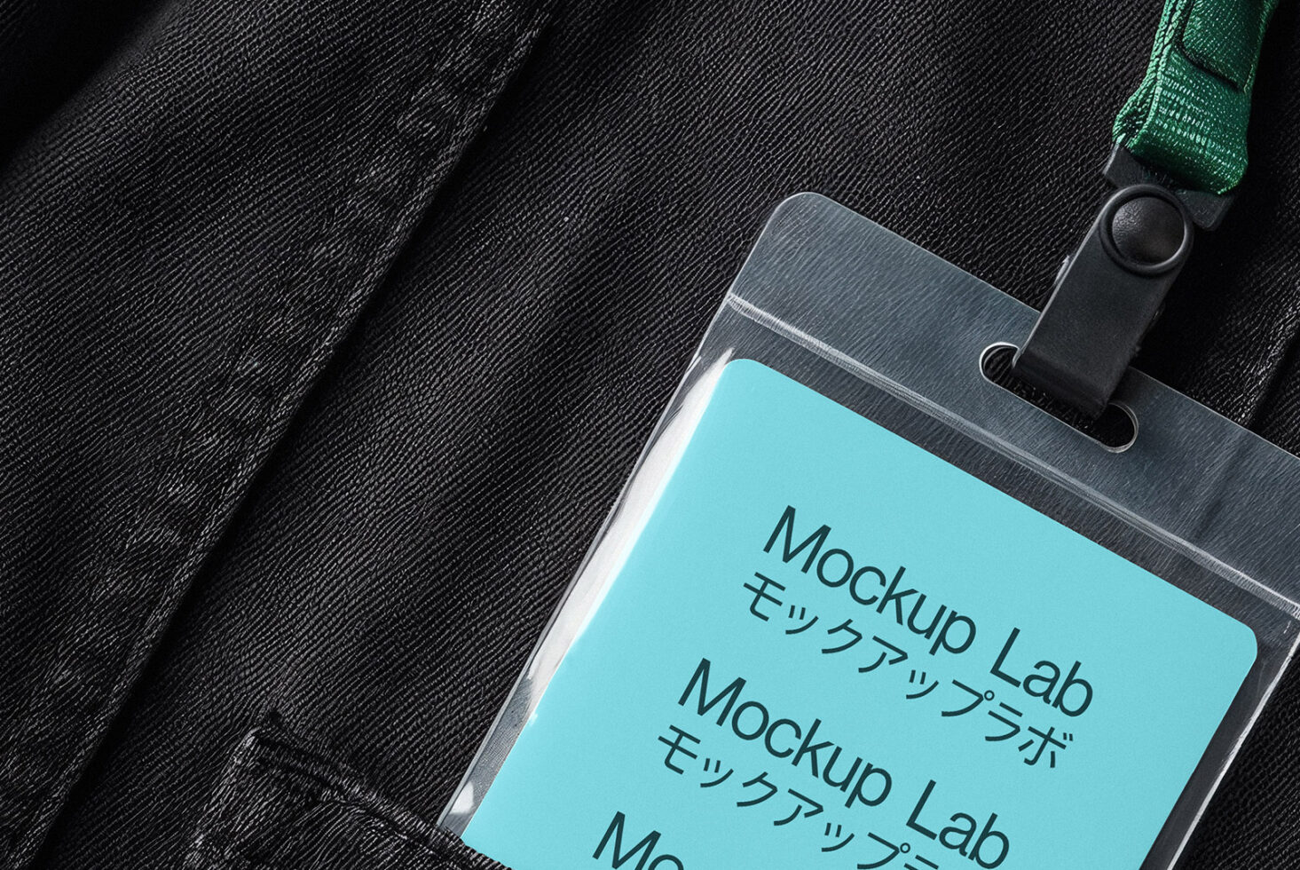 Cyan ID card mockup with green lanyard on black textured fabric