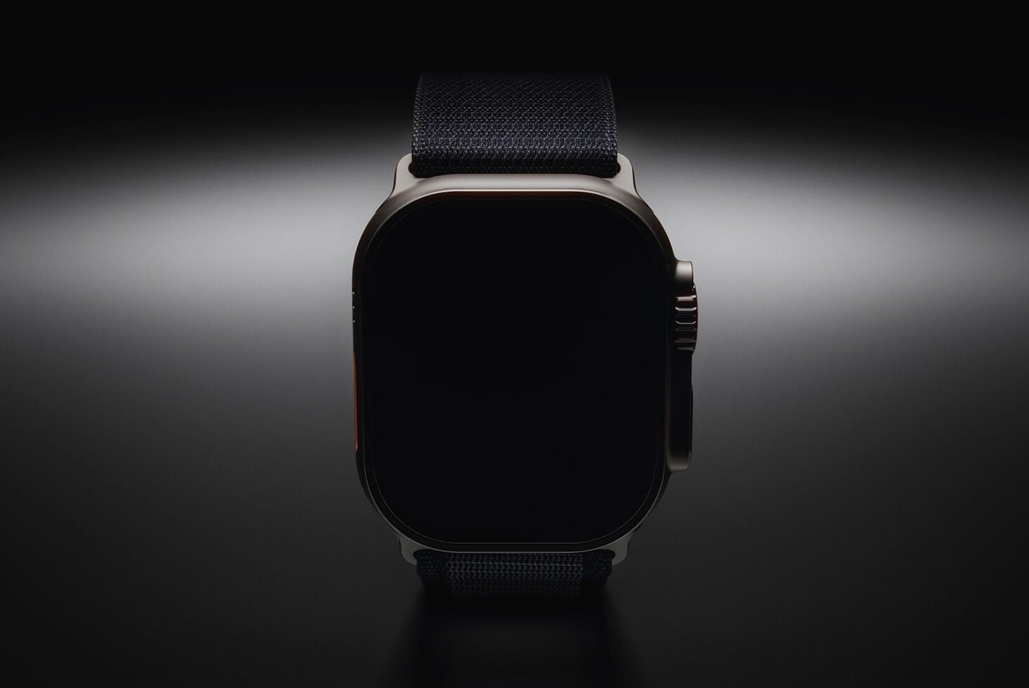 Smartwatch with black strap, blank screen, front view on gray background