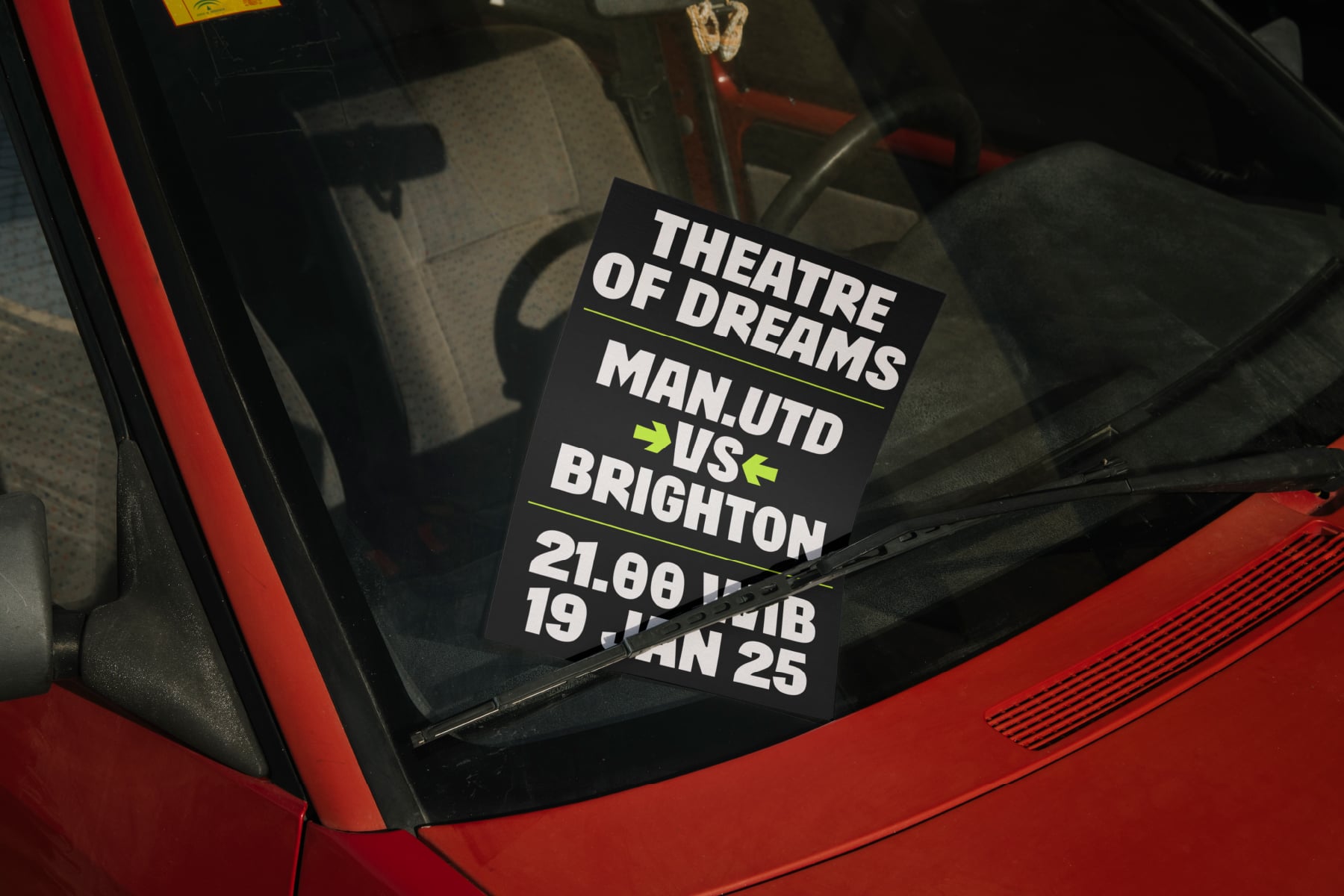 Black car windshield sticker showing white text theatre of dreams with yellow accents