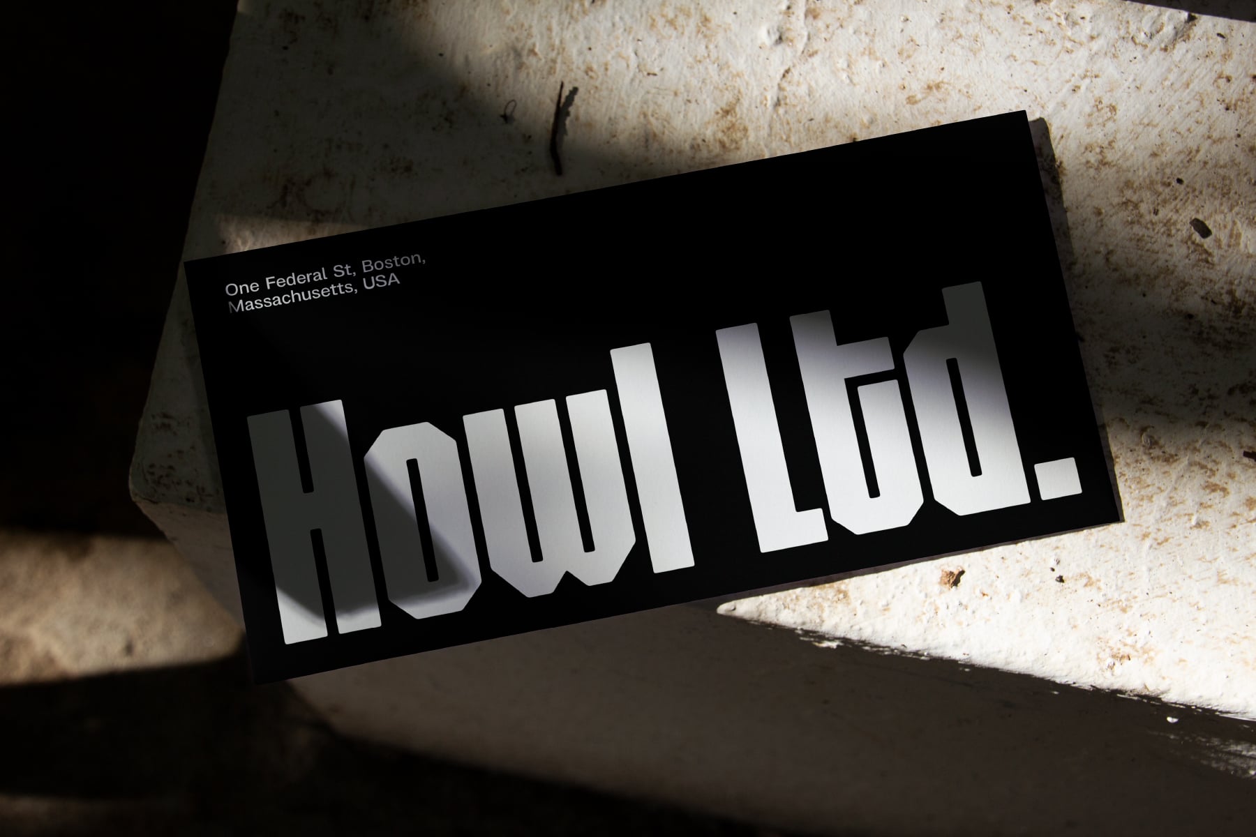 Houil typeface on black business card in concrete setting