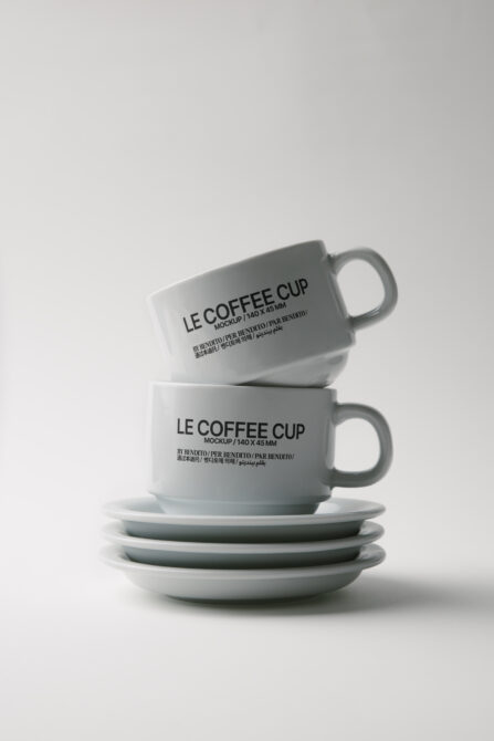Stacked ceramic coffee cup mockups with matching saucers on light background